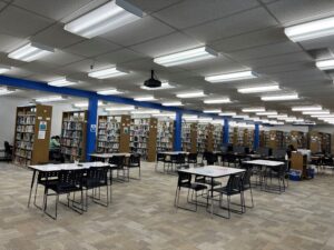 tables and chairs in open space for group work or studying with bookshelves in the distance